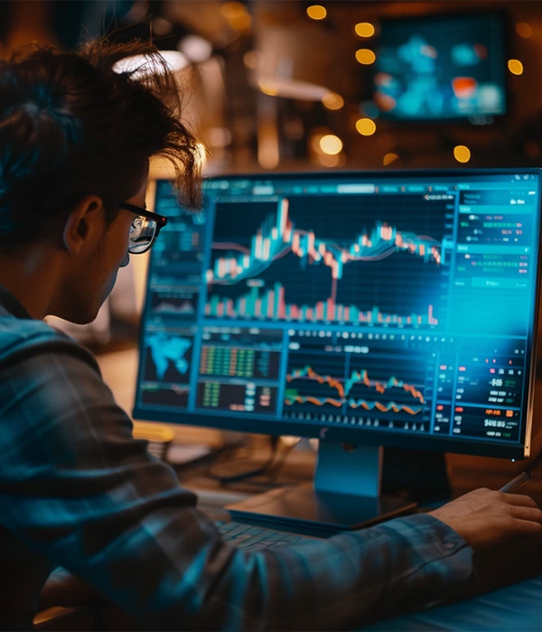 Man in front of a computer analyzing charts